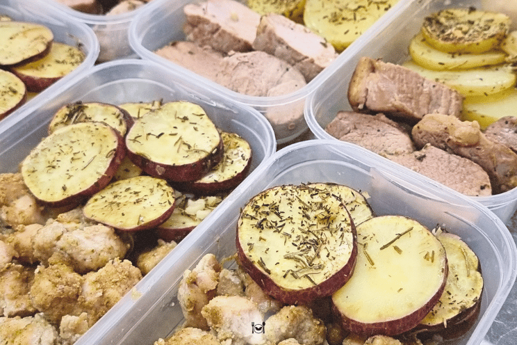 Pessoa preparando marmitas com alimentos frescos e coloridos em recipientes herm&eacute;ticos